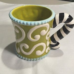Mud Pie mug, green/off-white/lt. blue/black, “Cheshire Cat” tail handle